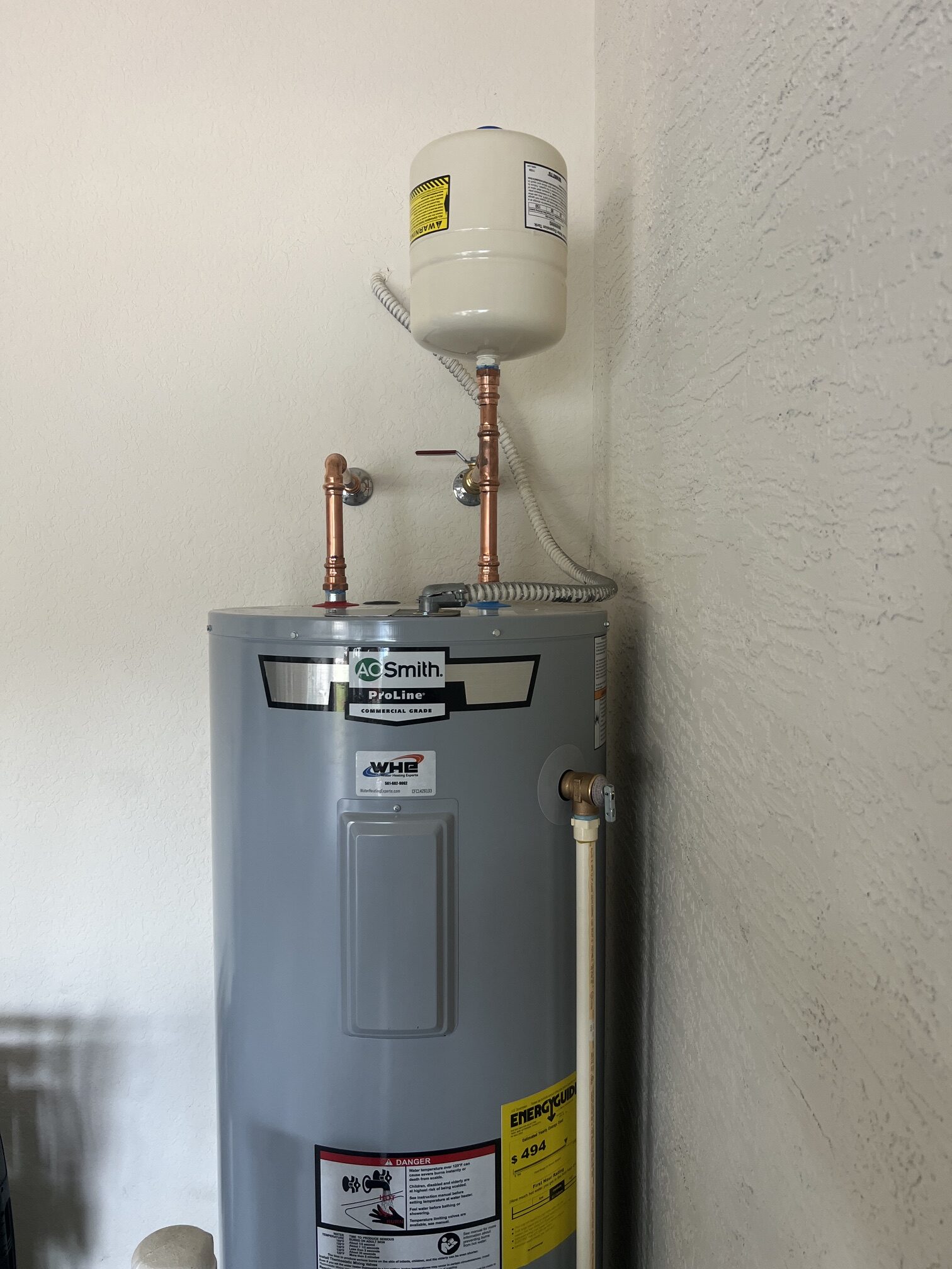 A. O. Smith electric tank water heater with copper connections and an expansion tank from WHE’s installation work